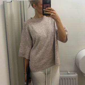 Beige stickad tröja - Säljer en mysig beige stickad tröja med trekvartsärm. Perfekt för kyligare dagar och enkel att matcha med olika outfits. Tröjan har en avslappnad passform och rund halsringning. Men tyvärr har jag tröttnat på den .