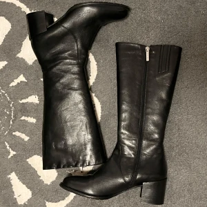 Svarta skinnstövlar Gino Rossi - Snygga svarta stövlar i skinn med dragkedja på sidan. Äkta läder och så fina och classy! Passar mig inte i vaderna därför jag säljer. Bara provade ❤️
