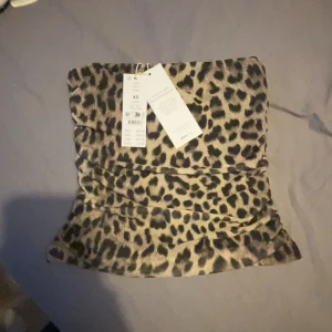Leopardmönstrad tubtopp - Snygg leopardmönstrad tubtopp i stretchigt material. Har fortfarande prislappen på sig därav aldrig använd. Den är dessutom slutsåld på Gina tricot hemsida❣️ (ljuset skiljer sig på bilderna eftersom jag har ganska gult ljus i mitt rum)