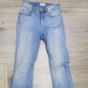 Blå bootcut jeans från ONLY - Säljer ett par snygga blå bootcut jeans från ONLY i storlek XS. De har en klassisk femficksdesign och är i mycket bra skick. Perfekta för både vardag och fest! 👖💙