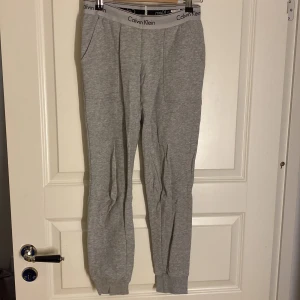 Grå mjukisbyxor från Calvin Klein - Säljer ett par grå mjukisbyxor från Calvin Klein med elastisk midja och logotypdetaljer. 