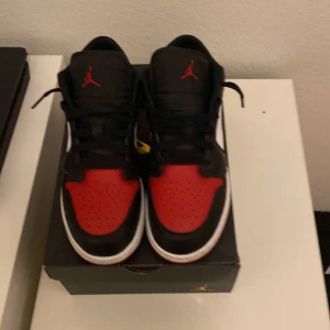 Nike Air Jordans i svart, röd och vit - Snygga Nike Air Jordans i klassisk svart, röd och vit färgkombination. Skorna har en ikonisk design med snörning och den välkända Jumpman-loggan på plösen. Perfekta för sneaker-entusiaster. Köpt för 1300 