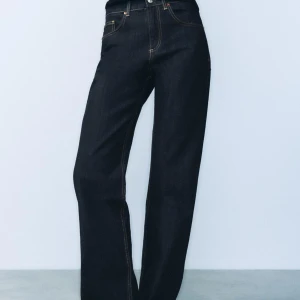 Svarta jeans med hög midja - Säljer ett par snygga mörkblåa jeans med medelhög/låg och lite baggy. De har en klassisk femficksdesign och kontrasterande sömmar som ger en cool look. Perfekta för både vardag och fest! 🖤