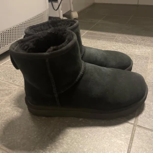 UGGS classic mini II - Säljer dessa uggs classic mini som har blivit använda ca 10 ggr förra vintern, svarta i strl 38. Somsagt använda men är inte direkt slitna utan mer att det syns tecken på användning💞