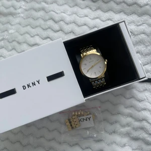 Damklocka DKNY - Säljer en stilren guldfärgad klocka från DKNY i nytt skick. Använd fåtal gånger. Kommer i originalförpackning med extra länkar och garantihäfte.