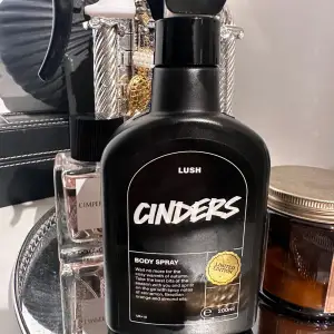 Säljer en limited edition Cinders Body Spray från Lush. Flaskan är svart och rymmer 200 ml. Doften är varm och kryddig med toner av kanel, apelsin och mandel. Perfekt för att känna sig mysig och fräsch under kalla dagar. Passa på innan den tar slut! Endast sprutat för att lukta på den!