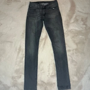 Nudie jeans - Säljer ett par riktigt fräscha nudie jeans i storlek 30/34. De har en skön fade vilket är fräscht till alla outfits. De är gråa med lite ljusare grå fade