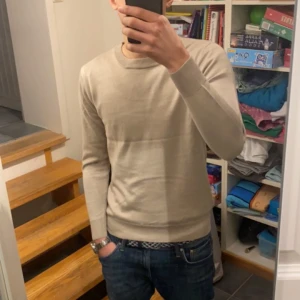 Beige kashmirtröja - Säljer en stilren beige kashmirtröja. Perfekt för en avslappnad look. Tröjan har en enkel design och passar bra till jeans.