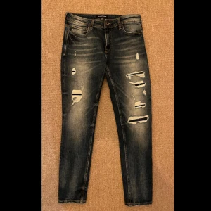 Jeans med slitningar  - Mörkblå jeans med slitningar från smog, storlek 31/32, skick 9/10, skriv om du har frågor✅🤗