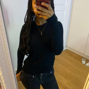 Svart långärmad tröja - Säljer en stilren svart långärmad tröja i mycket bra skick. Perfekt för både vardag och festliga tillfällen. Tröjan har en normal passform och är gjord i ett mjukt material som känns skönt mot huden. Passar perfekt till jeans eller kjol för en avslappnad look.💗