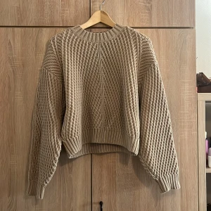 Beige stickad tröja från H&M - Säljer en superfin beige stickad tröja från H&M i storlek XS. Den har en mysig och varm känsla med ett snyggt stickat mönster. Perfekt för höst och vinter! Tröjan har långa ärmar och ribbade muddar vid ärmslut och nederkant. Den är markerad XS men passar även S och M!