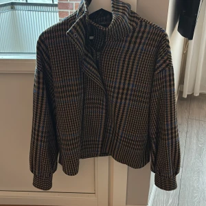 Rutig jacka med dragkedja - Snygg rutig jacka med dragkedja och hög krage. 