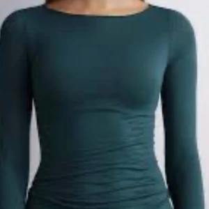 Mörkgrön långärmad topp - Snygg mörkgrön långärmad topp med en tight passform. Tillverkad i ett mjukt och stretchigt material.