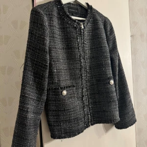 Svart jacka/kavaj från Stockh LM - Kavajen har en dragkedja framtill och dekorativa knappar på fickorna. Perfekt för en stilren look. Storlek s men passar även m. 