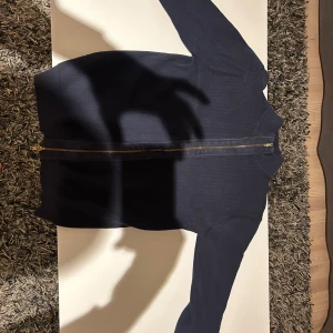 Mörkblå tröja John Henric zip - Snygg mörkblå tröja med dragkedja framtill. Perfekt för en avslappnad stil och enkel att matcha med andra plagg. Långärmad design som passar bra för kyligare dagar.