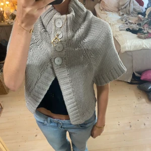 Grå stickad poncho med knappar - SUPER snygg!! Tryck gärna på köp nu❤️❤️ super eftertraktad 
