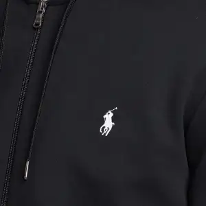 Snygg svart hoodie från Polo Ralph Lauren med dragkedja och klassisk logga på bröstet. Haft på ett par gånger och är köpt på Care of Carl för 1500kr pris ej hugget i sten