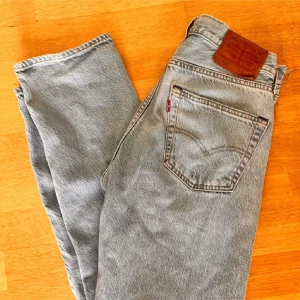 Ljus blåa Levis jeans - Säljer ett par klassiska grå Levis jeans med en straight passform. De har en midwaist och är tillverkade i jeansmaterial. Perfekta för en avslappnad stil.