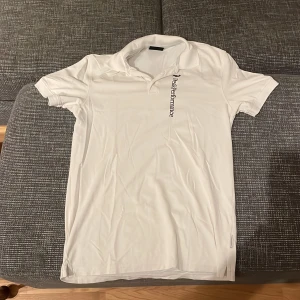 Vit pikétröja från Peak Performance - Säljer en stilren vit pikétröja från Peak Performance i storlek M. Tröjan har korta ärmar och en klassisk krage. Perfekt för både vardag och sportiga aktiviteter. Den är i mycket bra skick och redo för nya äventyr! Pris går alltid att förhandlas!