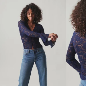 Mörkblå spetsblus - Säljer en elegant mörkblå spetsblus med långa ärmar och v-ringad design. Perfekt för en kväll ute eller en speciell tillställning. Blusen har en fin passform och är både stilren och bekväm.