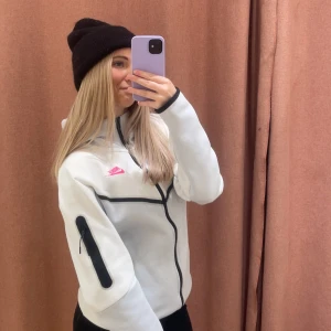 Nike tech fleece - Säljer en vit nike tech fleece med rosa nike märke. Den är i mycket bra skick, använd lite till och från bara. Matchande byxor ligger också ute till försäljning. (kolla bild 2)