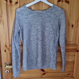 Grå stickad tröja - Säljer en mysig grå stickad tröja. Tröjan har en enkel design med långa ärmar och en rund halsringning. Den är i bra skick och passar till både vardag och lite finare tillfällen. Perfekt att matcha med jeans eller kjol!