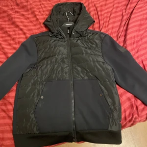 Cardigan Jacka BOSS  - Riktigt skön cardigan som är i nyskick och perfekt inför kommande väder. Använd enstaka gånger, dragkedja finns vid luvan då det finns en inre luva som visar BOSS text,  fler bilder kan skickas vid förfrågan!, nypris ligger på ungefär 3000kr