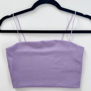 Ljuslila croppat linne - Ett ljuslila croppat linne med smala axelband 💜 Linnet passar bra till mig som normalt har storlek S i toppar.  Aldrig använt 😚  Längd: 22 cm Byst: 74 cm