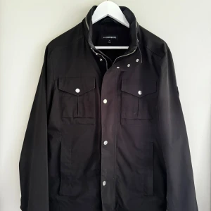 J.Lindeberg Bailey Poly fieldjacka - Snygg höst/vårjacka i nylonmaterial. Storlek M. Fint skick. Nypris var 3400kr Färgen är svart. 1000kr