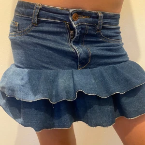 Jeanskjol med volang - Jeanskjol med volang som jag har sytt själv av ett par jeans 🩷Skulle säga att den passar XS 🫶 Midjemåttet rakt över är 30cm 🌸Måttet där volangen börjar är 35cm. Skriv vid intresse och pris kan diskuteras 🫶🫶