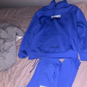 Blå hoodie och byxor från Hoodrich, ny skick - Säljer en blå dress från Hoodrich. Hoodien har en stor logga på både framsidan och baksidan, samt på ärmen. Perfekt för en casual look och superbekväm med sin mjuka insida. Passar perfekt för höst och vinter!