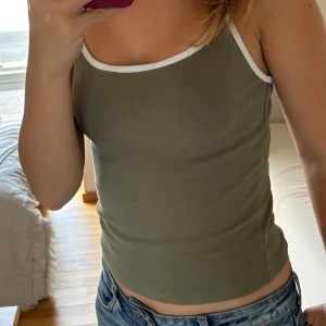 Grönt och vit linne  - Grönt linne med vita detaljer från Bikbok. Använts två gånger men fortfarande i bra skick och är i storlek S