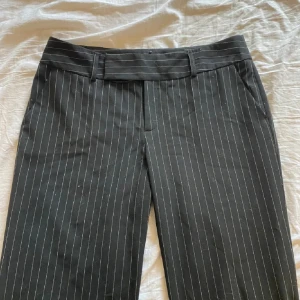 Lågmidjade svart vita randiga kostymbyxor  - Hej! Säljer dessa ursnygga kostymbyxor som är svart vit randiga. Jag är en storlek 38 så de är för tajta på mig, dessa är i storlek 34 och passar fint 34/36. Går inte att knäppa för mig vilket är synd för passformen är skit snygg. Pris kan diskuteras