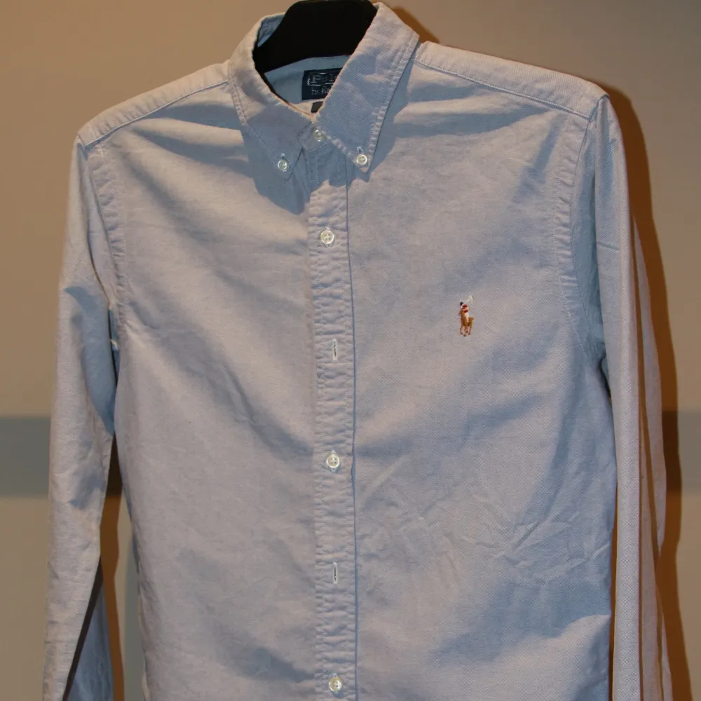 Slim Fit Polo Ralph Lauren blue skjorta.             Nypris: ca 1 500kr. Storlek:S Skick: 9/10 Mått (cm): Ärmlängd: 85. Bröstvidd: 92. Midjevidd: 86. Plagglängd: 76. Tveka inte på att höra av dig vid frågor!. Skjortor.