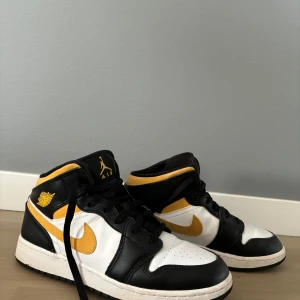 Nike Air Jordans i svart, vitt och gult - Säljer ett par snygga Nike Air Jordans i svart, vitt och gult. Skorna är i bra skick, bara använda ett fåtal gånger då de snabbt blev får små. Perfekta för både vardag och fest! Nypris: 1699kr.                 Pris kan diskuteras vid snabb affär. Hör av dig vid frågor. 