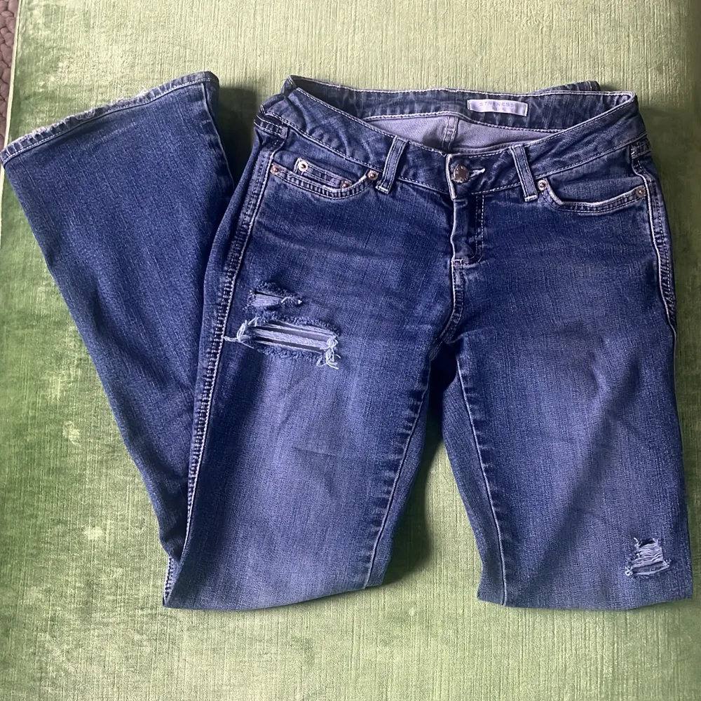 Jeans med skitsnygga slitningar, lågmidjade och bootcut. Mycket bra skick Midjemått: 37cm Innerbenslängd: 76cm. Jeans & Byxor.