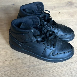 Svarta Nike Air Jordans - Säljer ett par svarta Nike Air Jordans i storlek herr 41. Skorna är i skinn och har en klassisk hög modell med snörning. Perfekta för både vardag och fest! ÄKTA