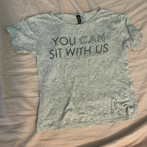 Grå t-shirt  - En grå t-shirt med text 