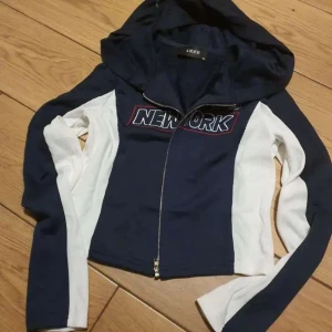 Tunn hoodie med New York Logo från Cidershop - Hej, jag vill sälja denna fina kofta från Cider, jag köpte den för ca 1 år sen och har aldrig haft på mig den ute enbart testat hemma. Tycker tröjan är ursnygg men ganska liten i storleken speciellt i XS. (Köpare står för frakten)