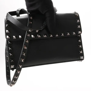 Valentino Garavani (äkta läder) - Säljer denna Valentino Garavani väskan i modell Rockstud Leathernecks Crossbody Bag. Använd några gånger. Nästan nyskick. Pris går att diskuteras. Köptes från Valentino butiken i London för 2 år sen. Färg: Guld och Svart. ValentinoDustbag finns med! 
