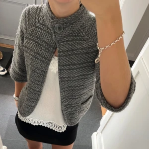 Grå stickad kofta - Trekvartsärmad grå stickad kofta från Street Ome i storlek 38. Passar S och M. Fint skick. Använd gärna köp nu!