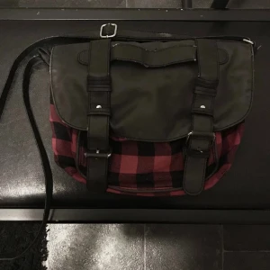 röd rutig väska  - röd rutig axelremsväska , super fin men blir inte till användning längre :) är sliten på ytter sidan men det borde funka att sy ! 