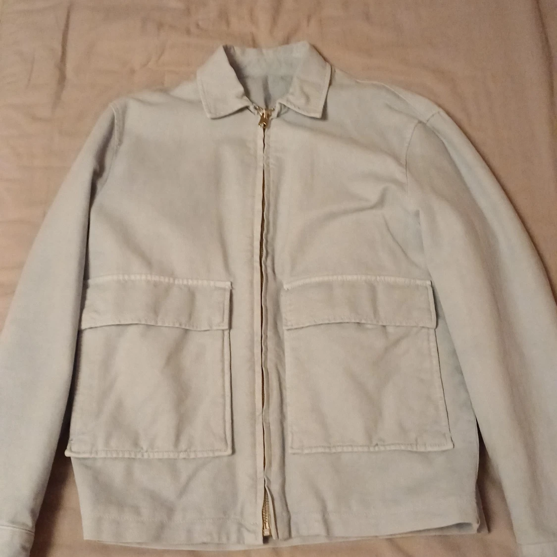 Ljusgrå jacka med dragkedja