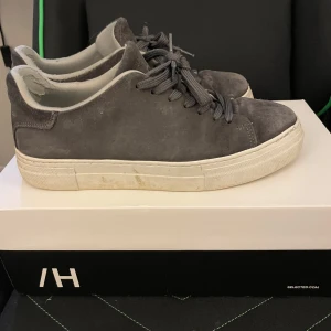 Grå sneakers från Selected Homme - Snygga grå sneakers från Selected Homme i mocka med snörning. Säljer för dom var allt för små för mig , storlek 40, på bilderna ser man vilket skick de är i. Kostade 1100 ny.