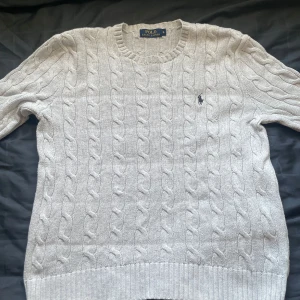 Grå kabelstickad tröja från Ralph Lauren - Säljer en grå kabelstickad tröja från Ralph Lauren, storlek S i mycket fint skick. Skriv gärna vid frågor