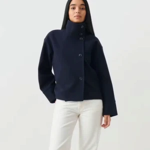 Mörkblå kappa med hög krage - Säljer den superpopulära och skutsålda korta kappan från Gina Tricot med hög krage och knappar framtill. Mörkblå i storlek S. Använd endast ett fåtal gånger och i mycket bra skick. Skriv för fler bilder eller frågor! Kan mötas i Stockholm.