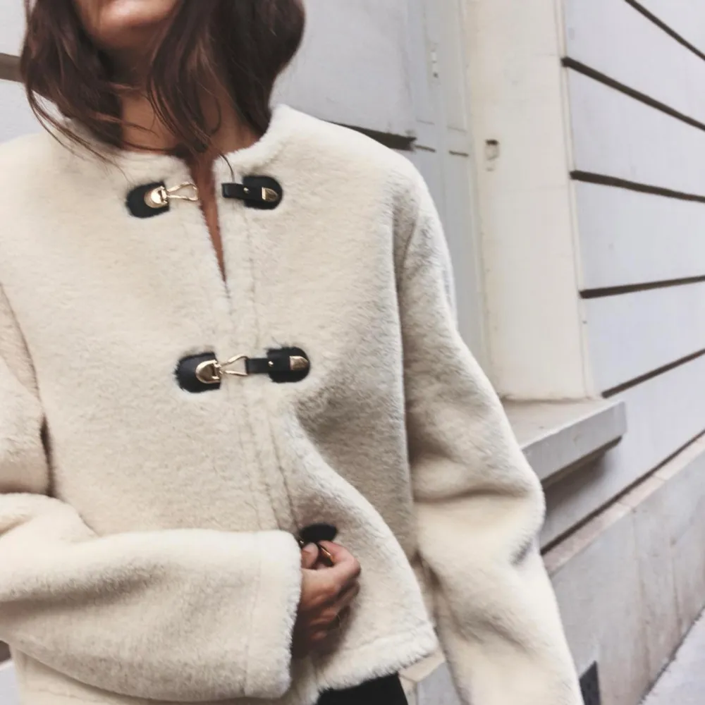 Säljer en supermjuk beige teddyjacka från Zara med snygga spännen framtill. Jackan har en croppad passform och långa ärmar, perfekt för kyliga dagar. Den är både stilren och mysig, ett måste i garderoben!helt ny med lappar kvar!. Takit.