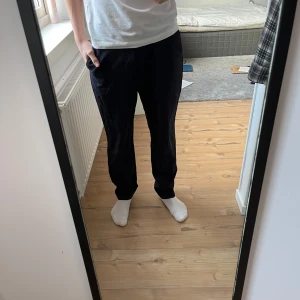 Svarta kostymbyxor - Snygga svarta kostymbyxor med en klassisk rak passform. Byxorna har en midwaist design och är perfekta för en stilren look. De är tillverkade i ett bekvämt material o är från hm. Använda typ 4 gånger. Storlek 170