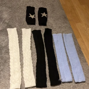 Flera par stickade handledsvärmare - Säljer flera par handledsvärmare i olika färger. Ett par vita och ett par svarta handledsvärmare, samt ett par ljusblå handledsvärmare. Handledsvärmarna är svarta med en vit stjärna. Perfekta för att hålla värmen under kalla dagar. De passar till alla olika stilar Emo, grunge, Y2k men även Stockholmsstil!💗Säljer 30 st eller 100 för alla men priset kan diskuteras. Skriv till mig för övriga frågor eller andra bilder! De svarta med stjärnor på är sålda!