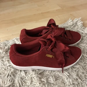 Röda sneakers från Puma - Snygga röda sneakers från Puma med breda snören och guldlogga på sidan och hälen. Dem är köpta från Sellpy men är knappt använda är i storlek 38,5❤️